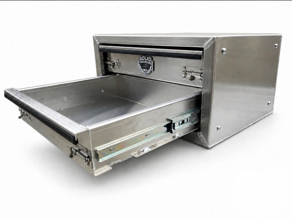A aluminium under-bed storage drawer with its front drawer pulled open, showing a spacious interior.  