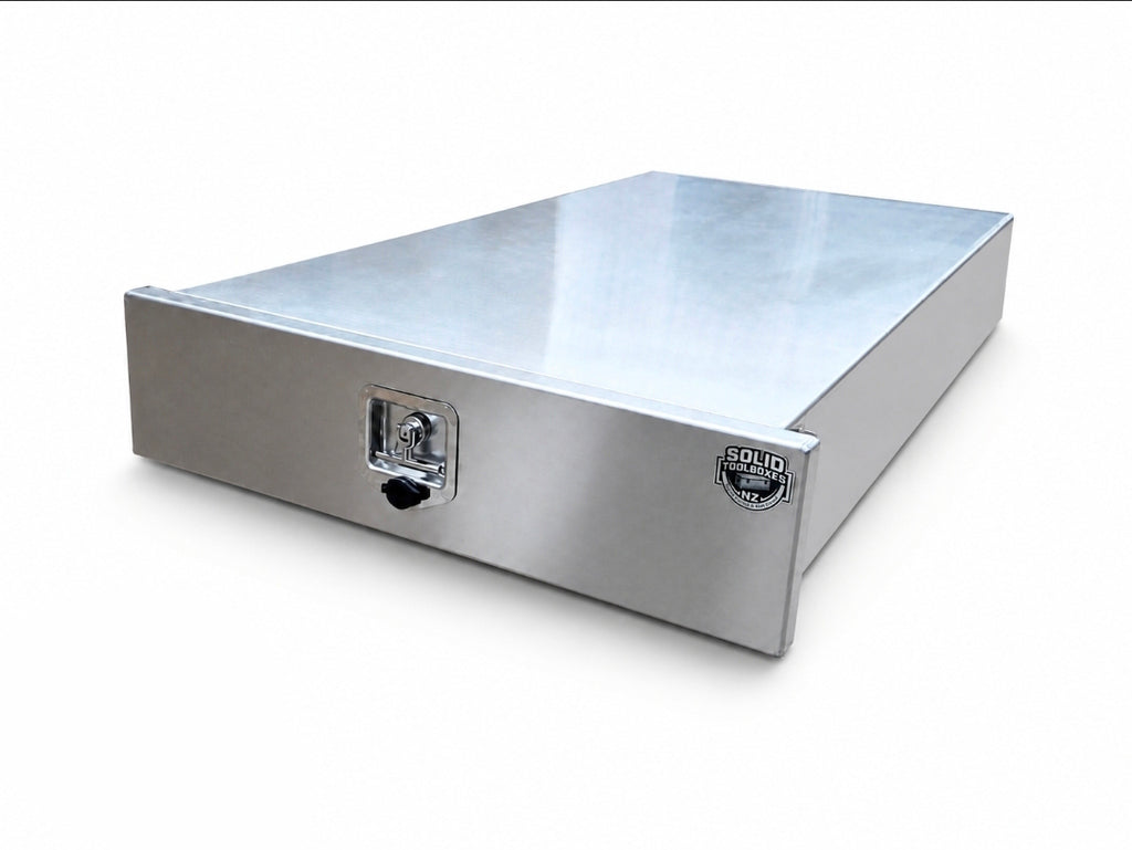 A rectangular aluminium storage drawer with a lockable front door and a small round badge on the side, photographed on a clean white background.