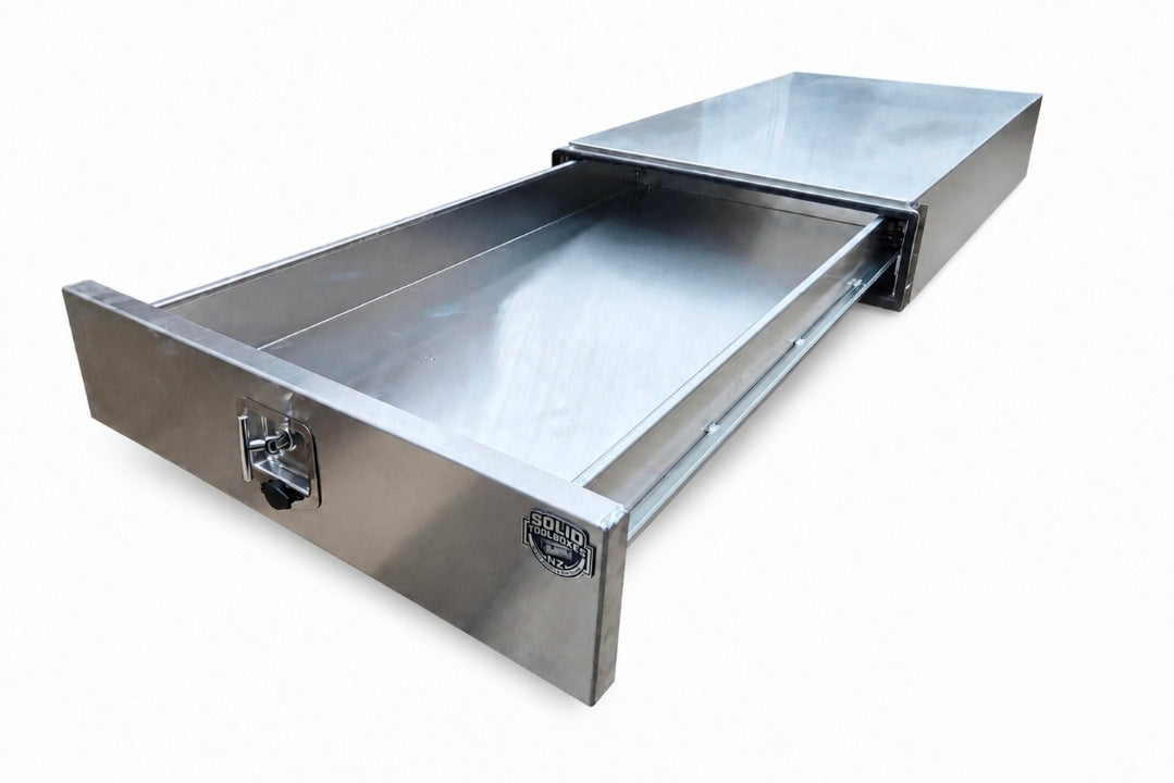 An aluminium under-counter drawer with one pull-out drawer extended, featuring a lock on the front.