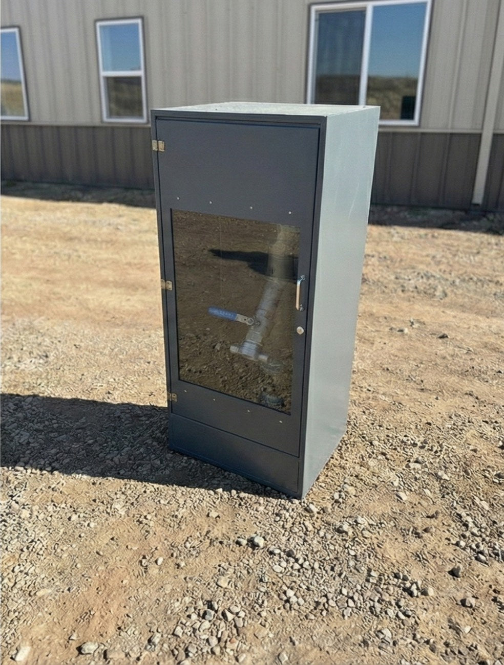 Charcoal riser cabinet installed on a concrete pad at a building site