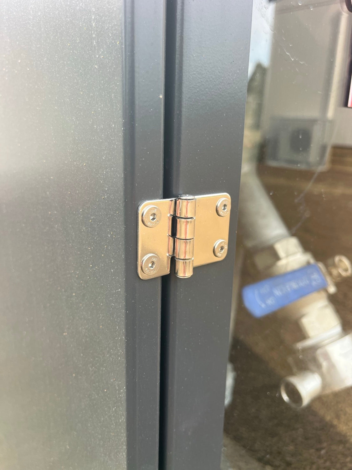 Chrome hinge fixed to a powdercoated cabinet door